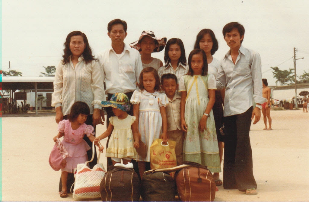 Oanh (bottom row left, in pink dress) with family members and friends in a UNHCR refugee camp in Malaysia in1982.